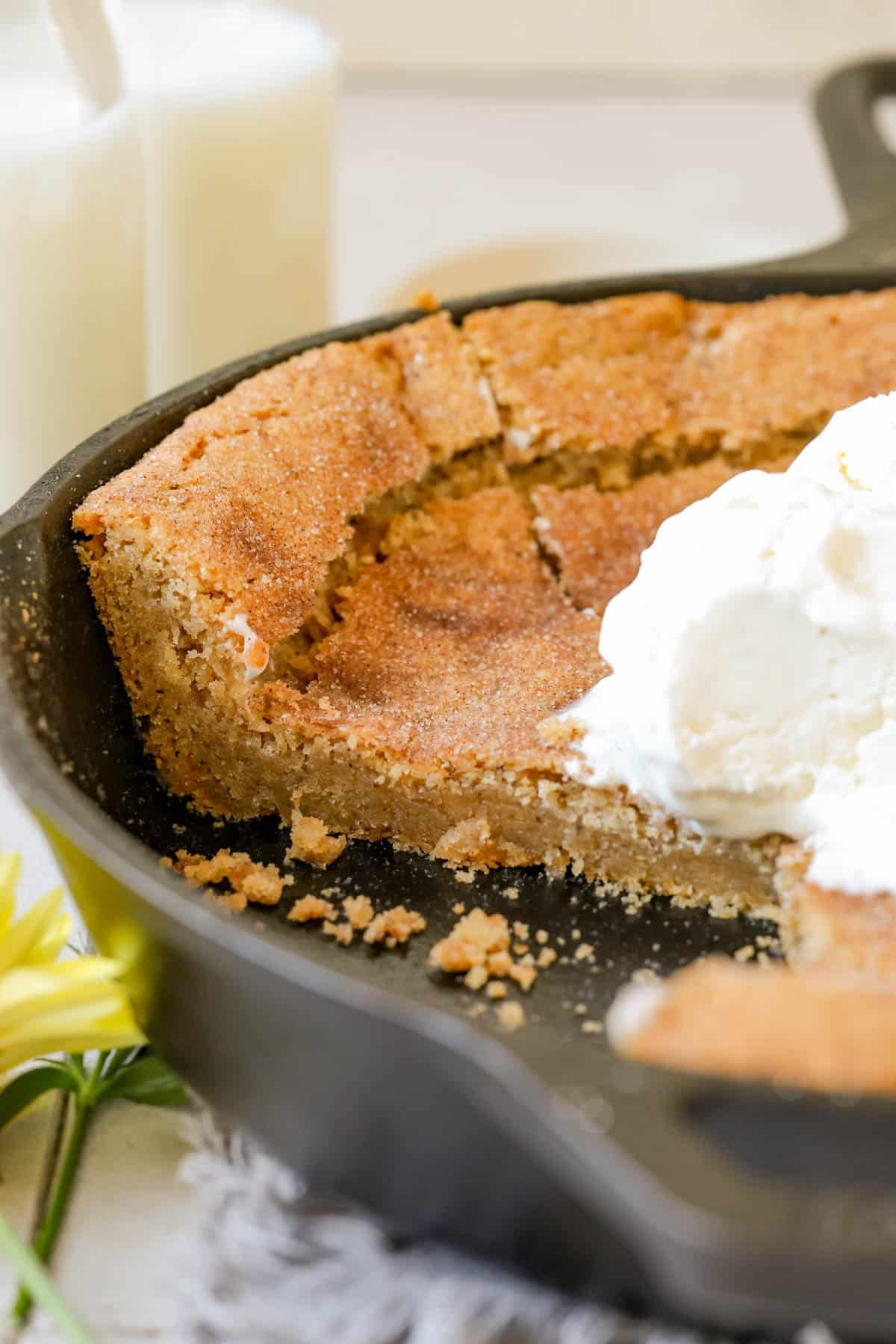 a slice on a cookie skillet topped with ice cream. 