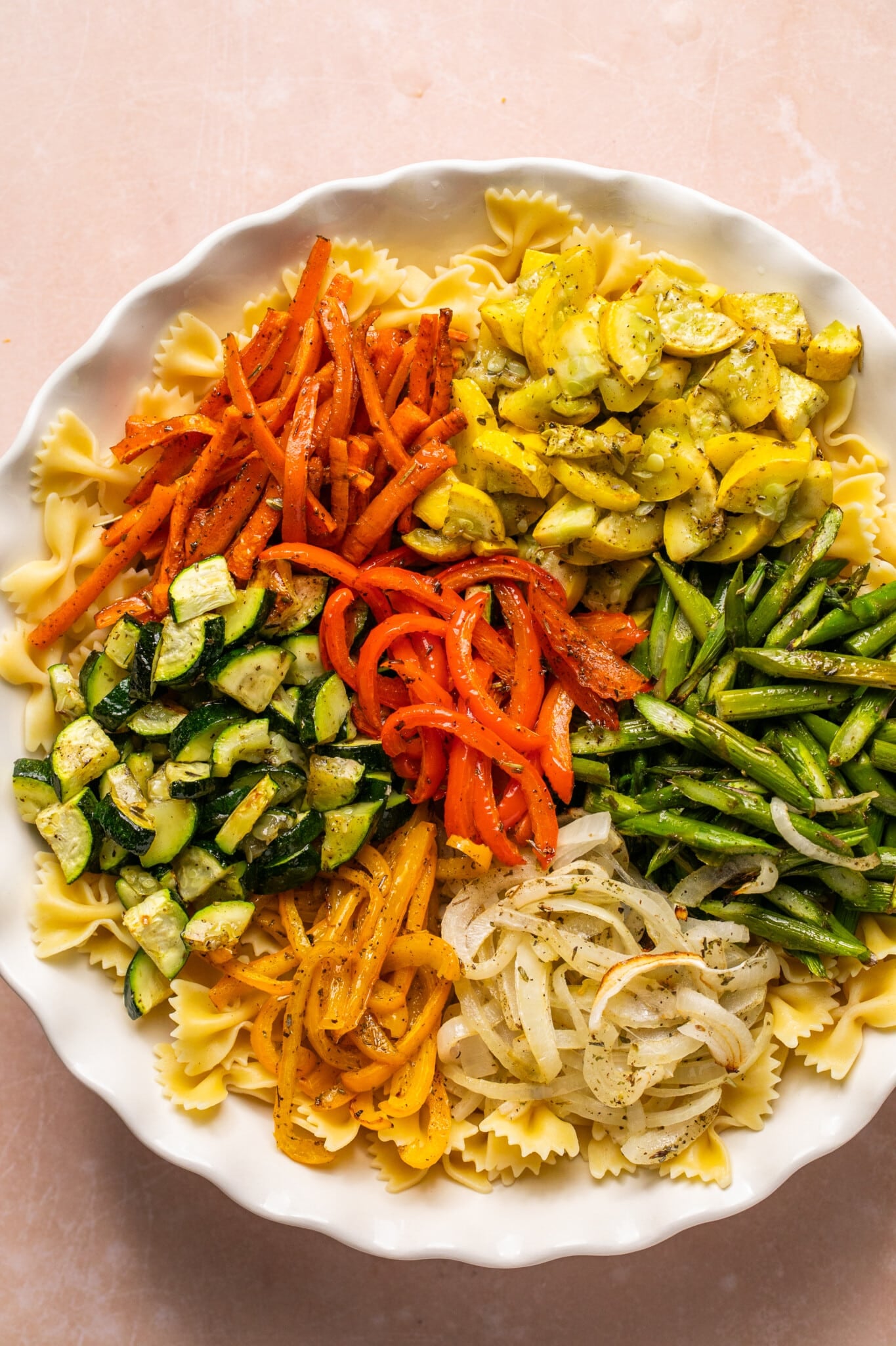 bow tie pasta in a large white bowl with roasted veggies. 