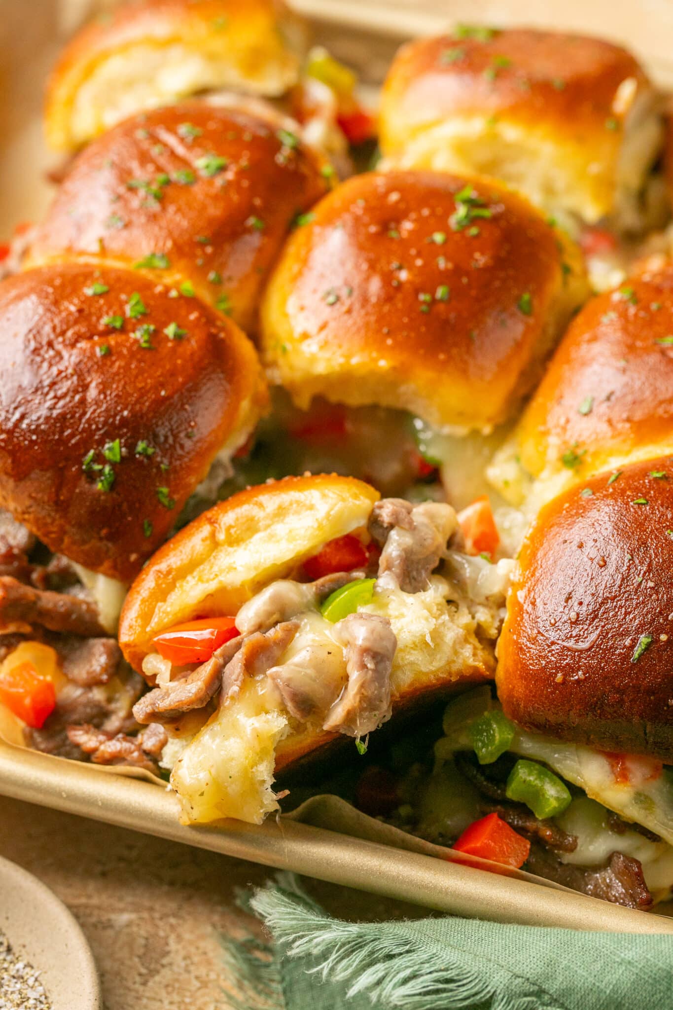 philly sliders on a gold baking sheet.