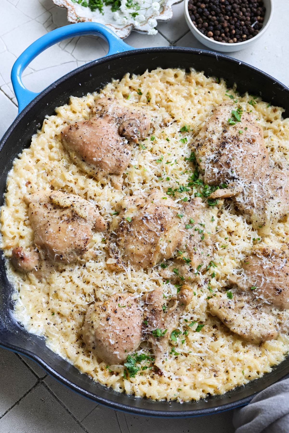 chicken and rice in a skillet garnished with fresh parsley. 