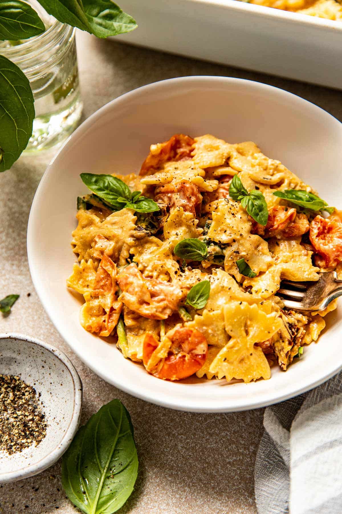 cream cheese pasta with cherry tomatoes and fresh basil in a bowl. 