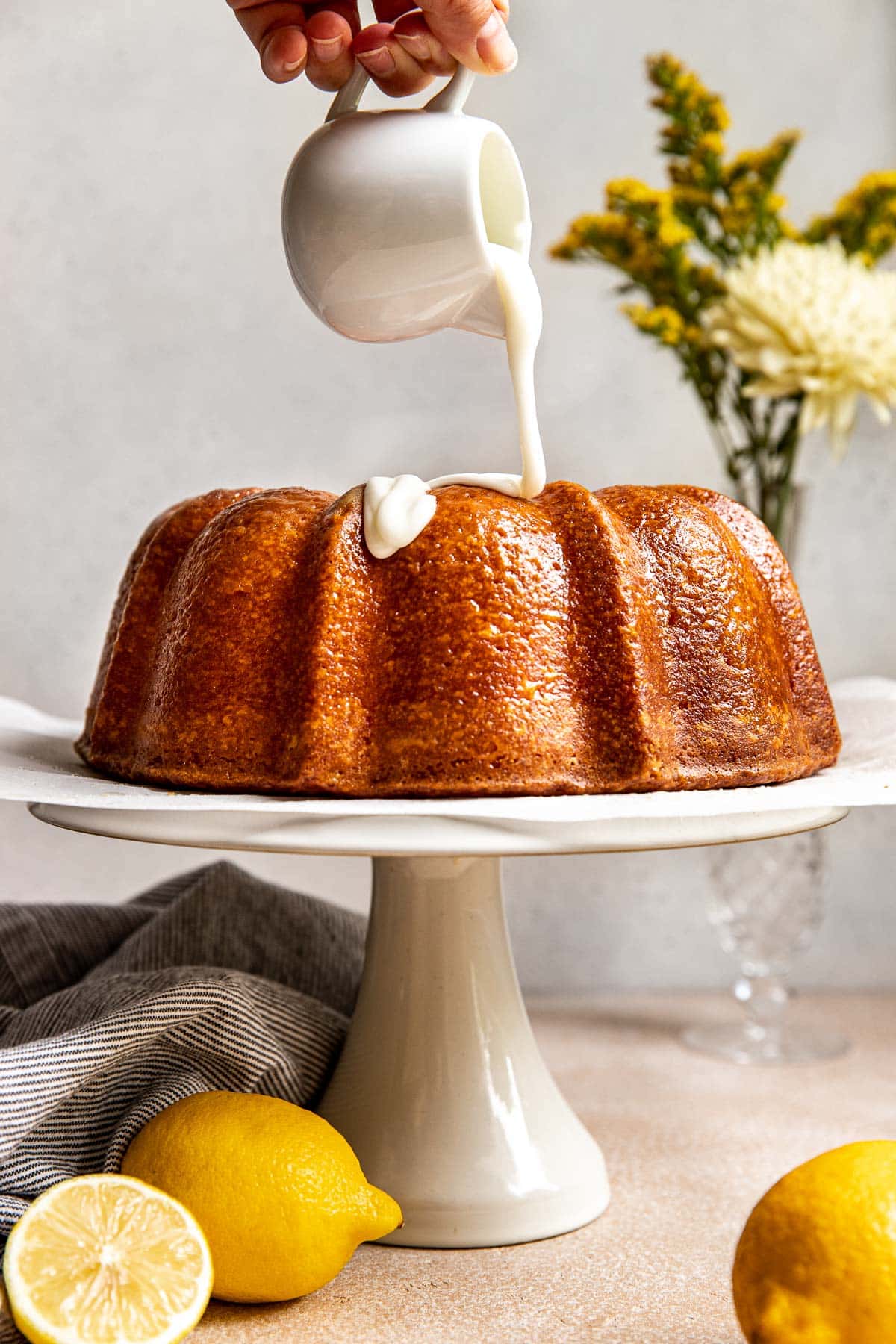 glaze being poured on lemon pound cake. 