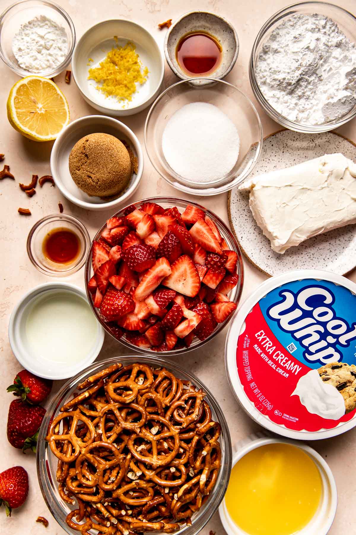 ingredients needed to make strawberry pretzel parfaits in glass bowls.