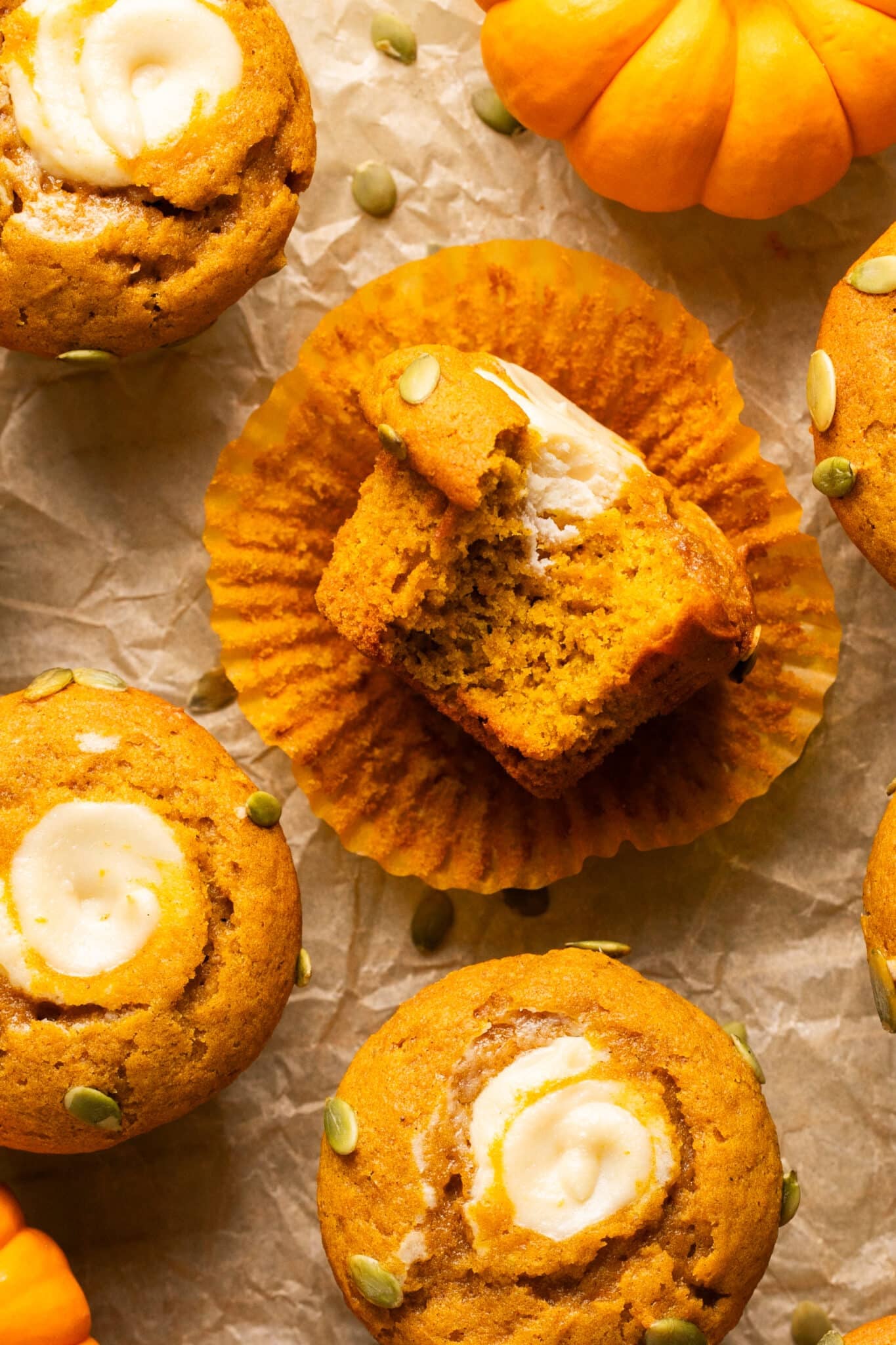a bite taken out of a pumpkin cream cheese muffin.