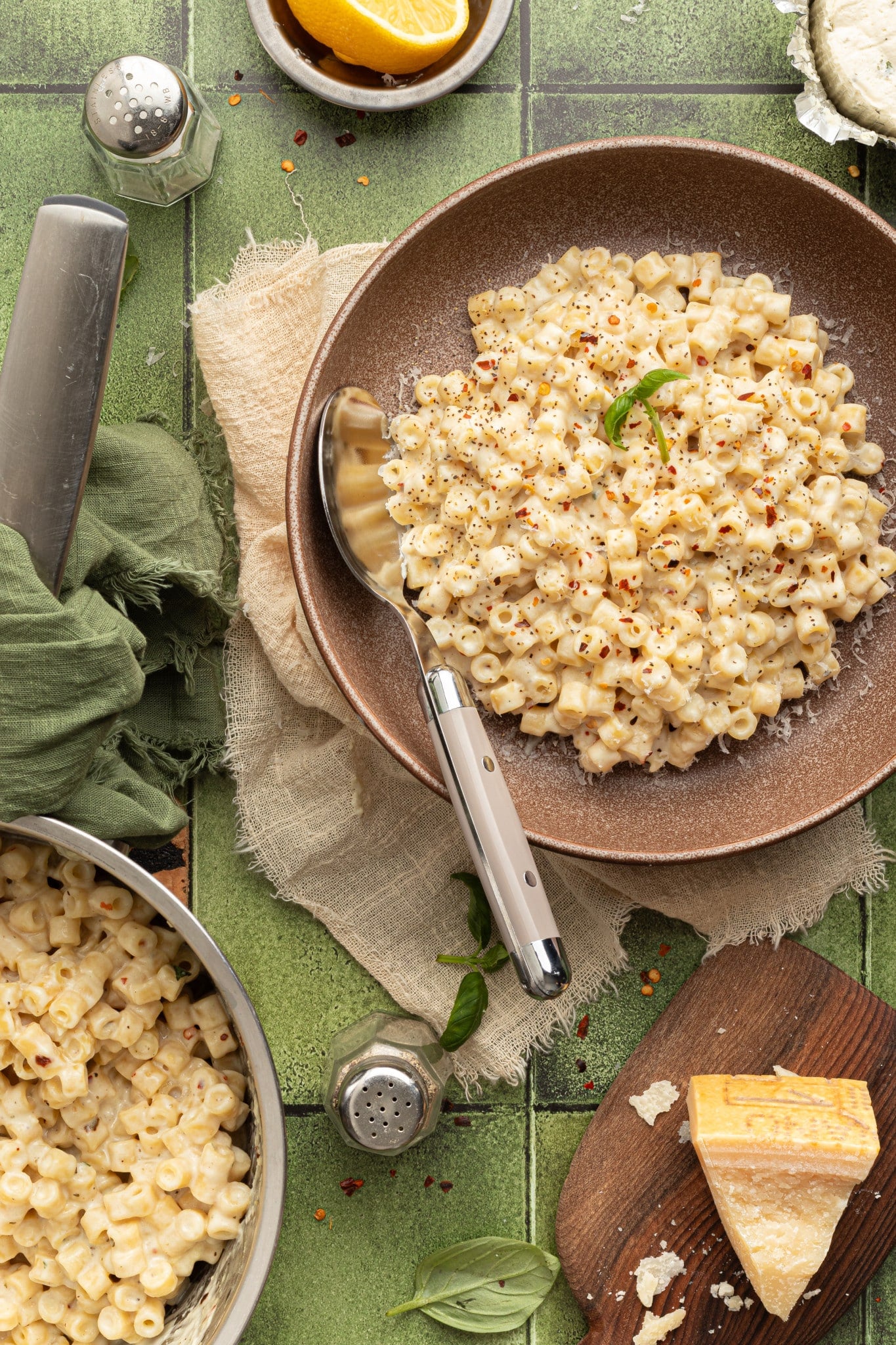 Creamy one pot boursin pasta in brown bowl with spoon on top of table scape.