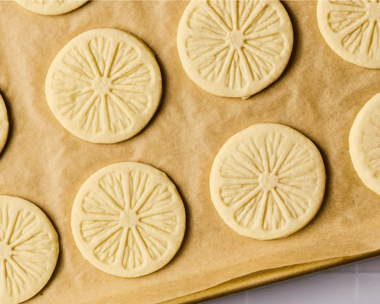 Copycat girl scout lemonade cookies baked on parchment paper lined baking sheet.