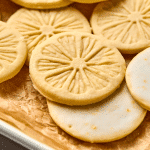 Upclose image of lemonades cookie on parchment-lined baking tray.