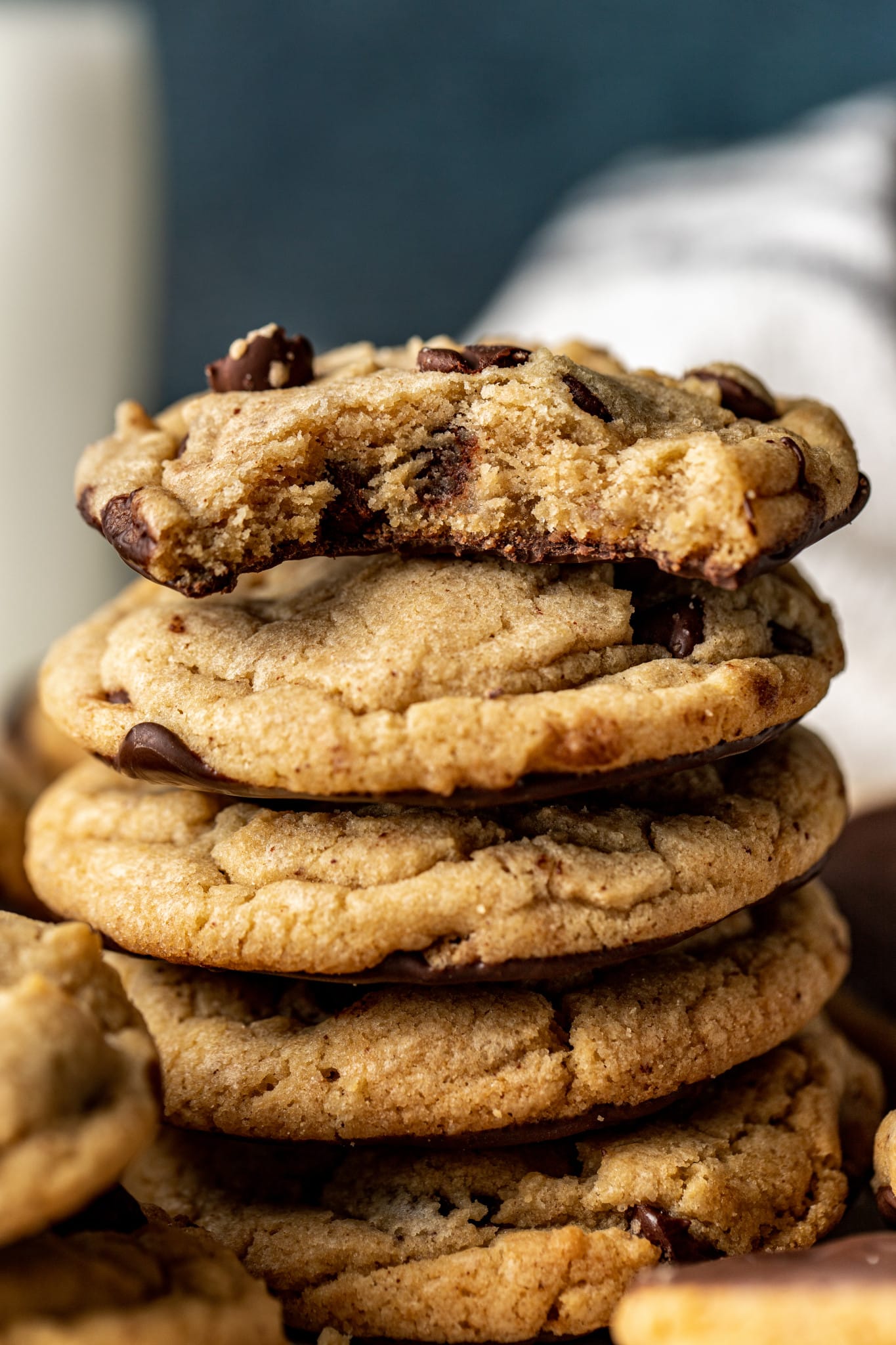 Stack of chocolate dipped chocolate dipped cookies. The top cookie has a bite taken out of it.