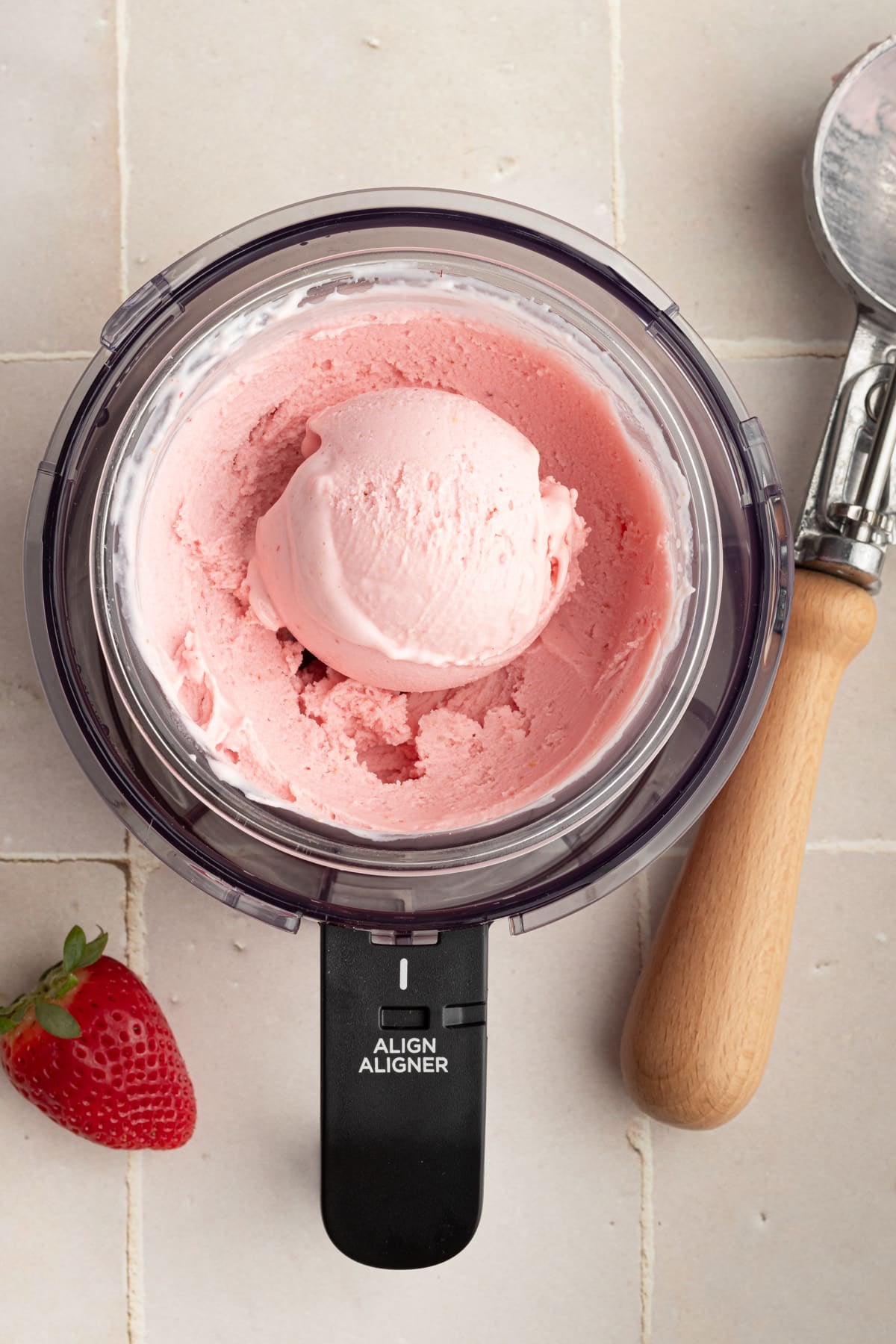 Ninja Creami strawberry frozen yogurt scooped in pint container inside outer bowl.