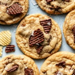 Baked chocolate potato chip cookies on table garnished with flaky sea salt.