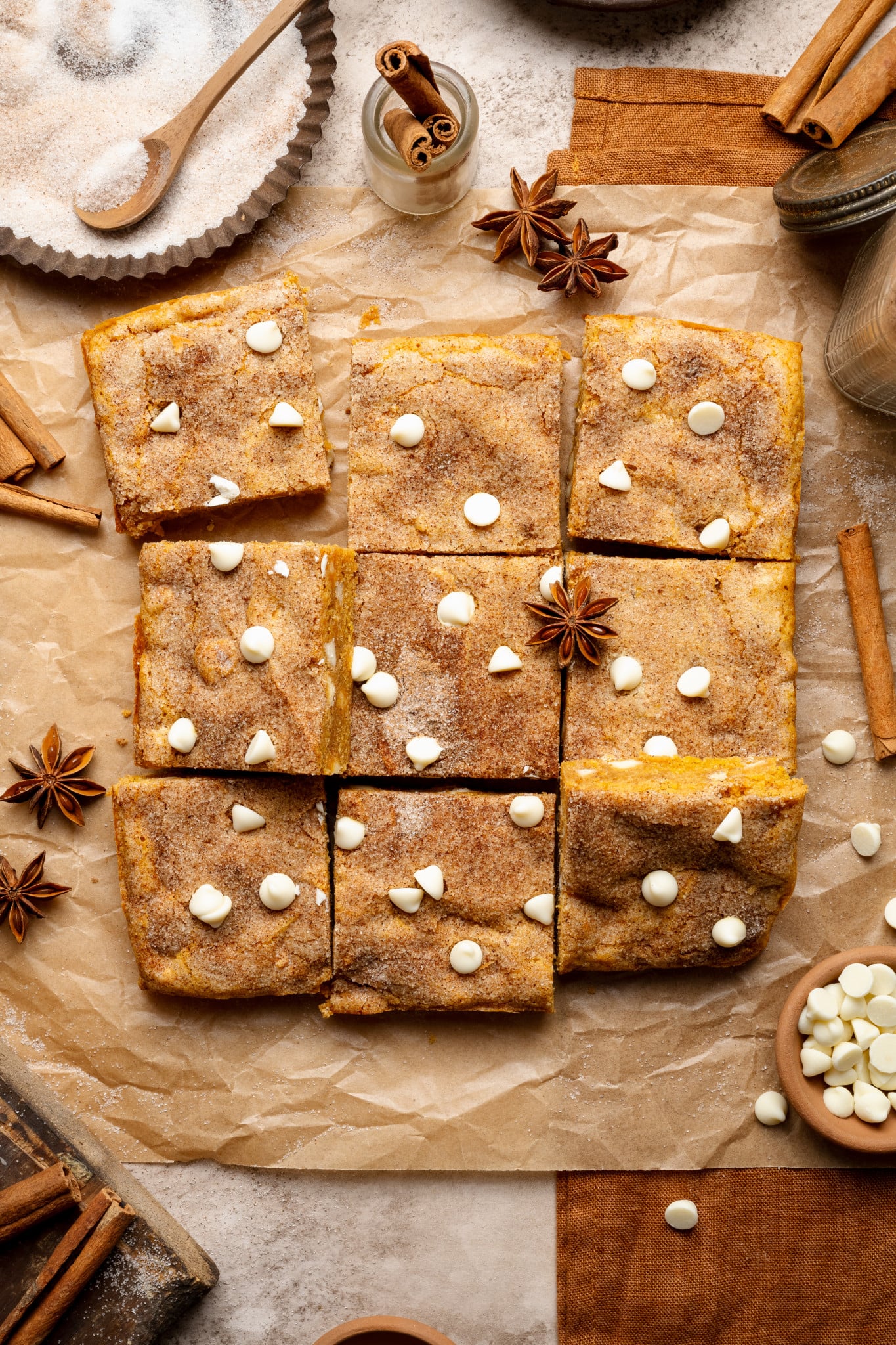 Pumpkin snickerdoodle blondies cut into 9 squares and garnished with cinnamon cloves.