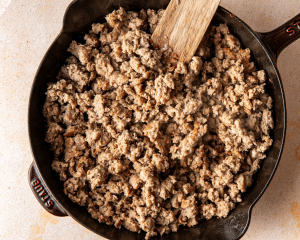 Italian sausage cooked in skillet before adding to slow cooker.
