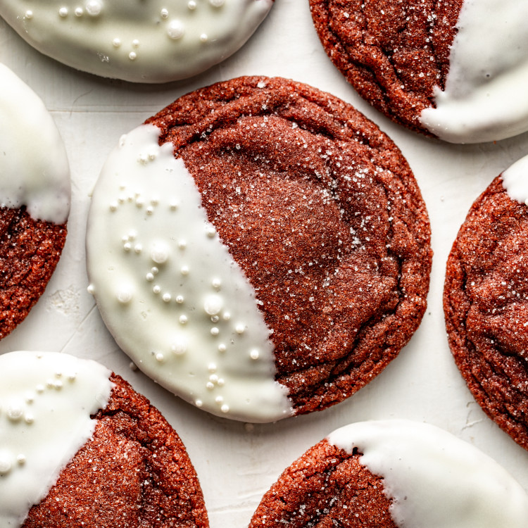 Red velvet cookie dipped in white chocolate and garnished with sprinkles and extra granulated sugar.