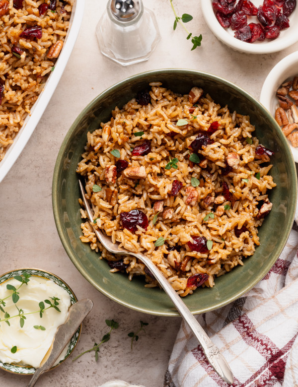 Holiday stick of butter rice in a green bowl with fork.