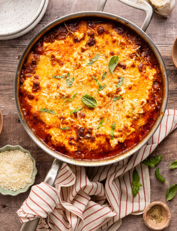 Gnocchi lasagna baked in stainless pot and garnished with fresh basil.