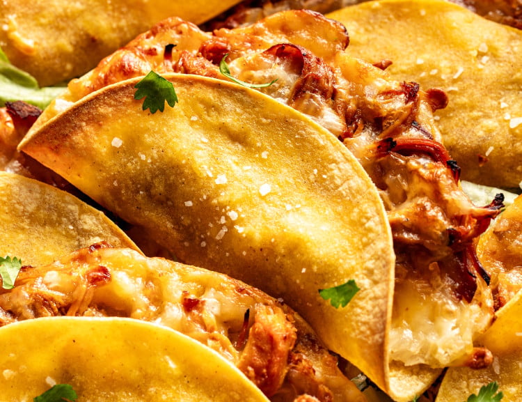 Honey chipotle chicken tacos baked and piled on top on each other.