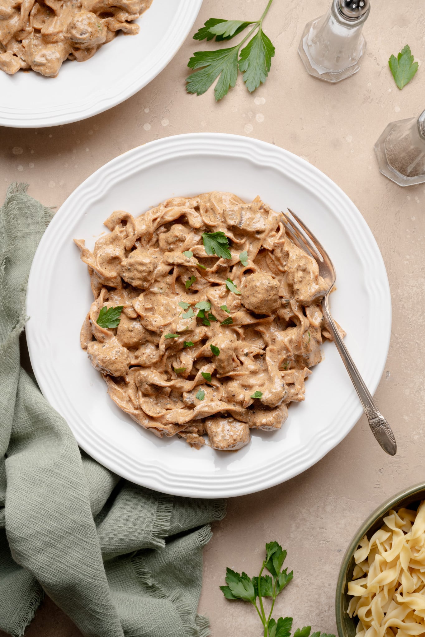 Beef stroganoff on a white plate with fork on the right side.