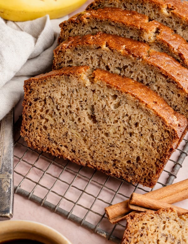 Slices of brown butter banana bread on wire rack.