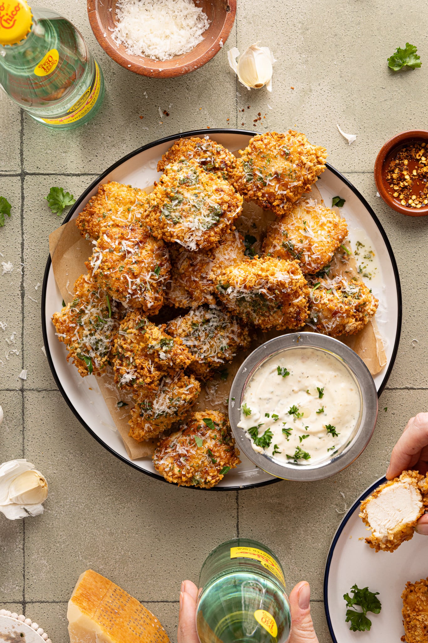 Plate of baked garlic parmesan boneless wings with a side of parmesan aioli on the side.
