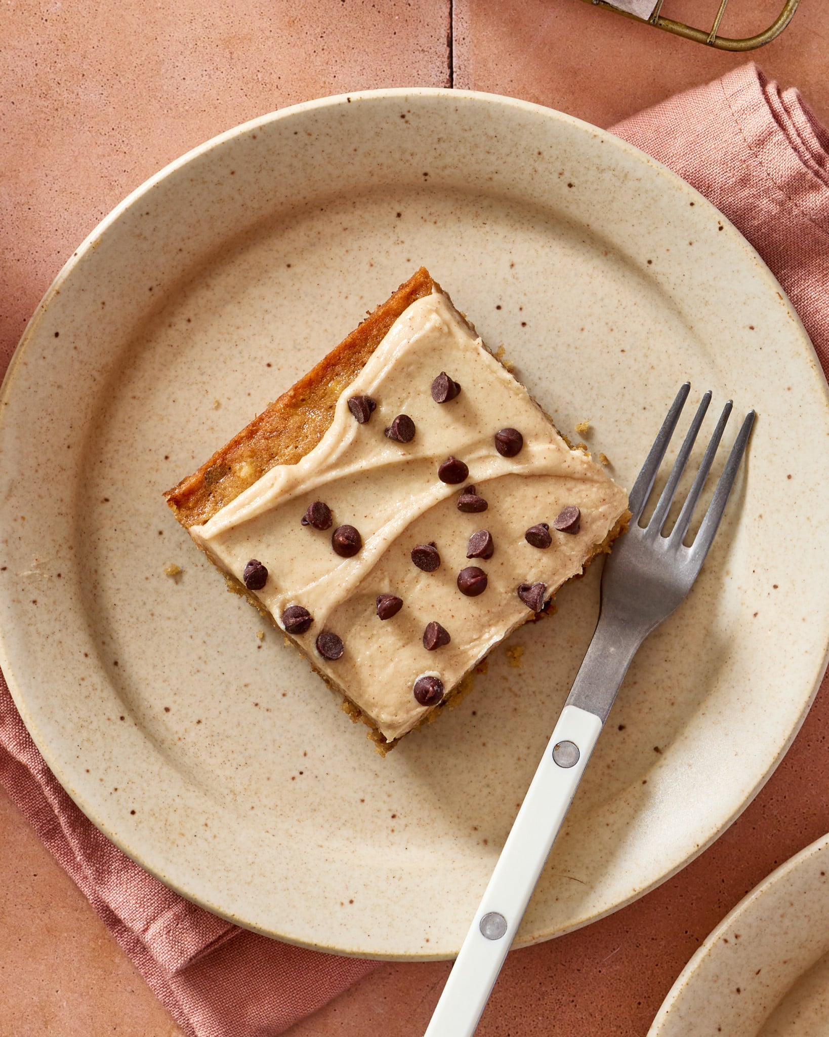 Banana chocolate chip bar cut and placed on plate with a fork.
