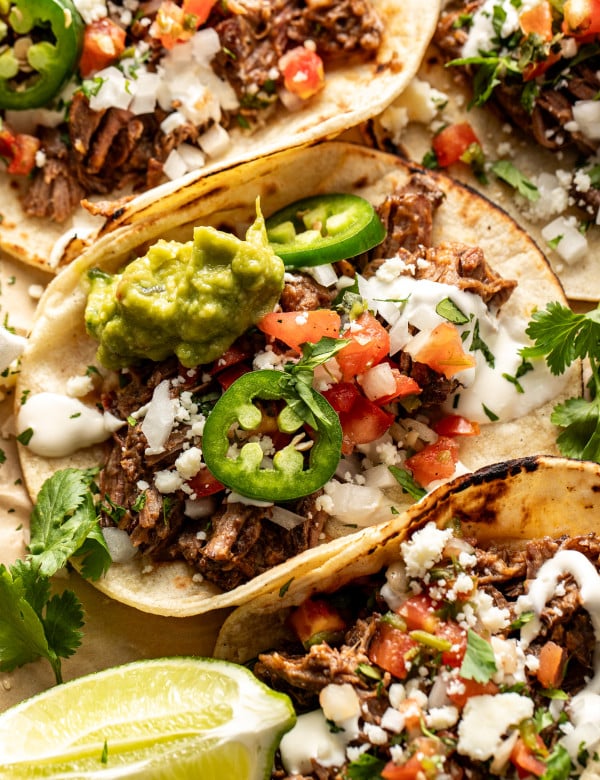 Beef barbacoa taco topping with fresh taco toppings.