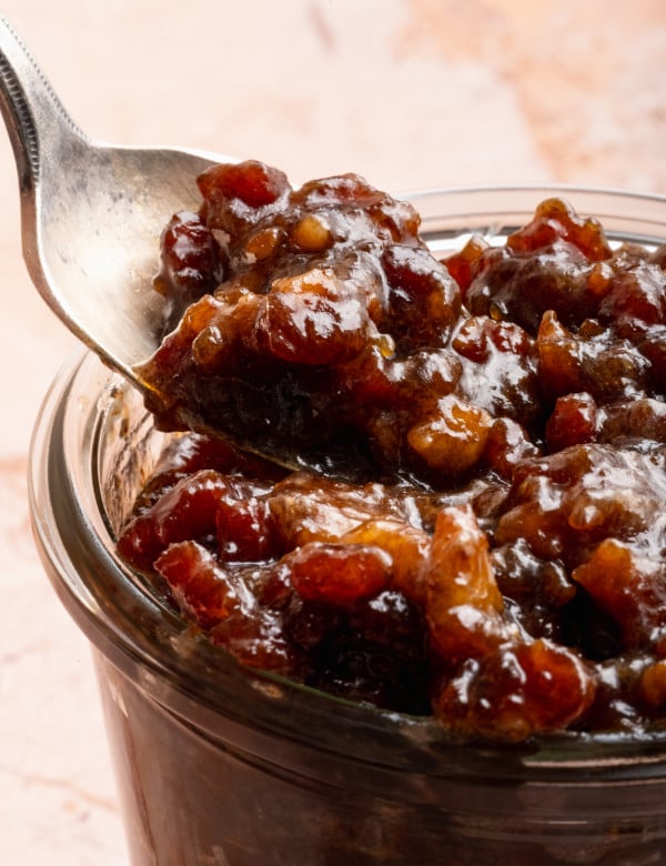 Spoon digging into jar of bacon jam.