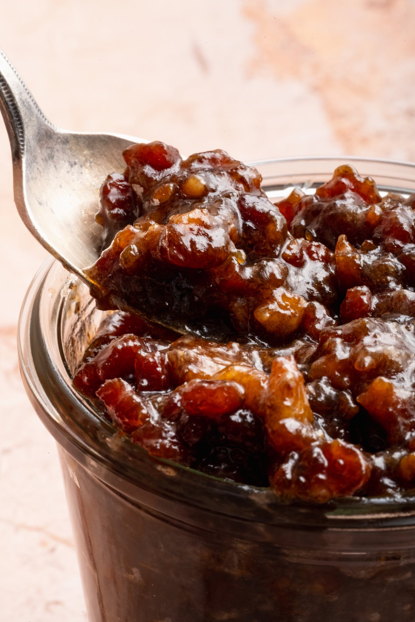 Spoon digging into jar of bacon jam.