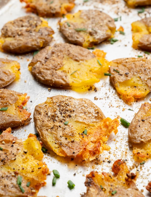 Upclose shot of crispy smashed potatoes on baking sheet.