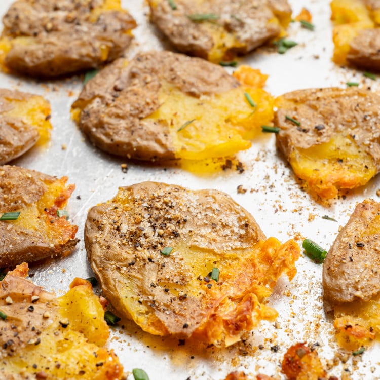 Upclose shot of crispy smashed potatoes on baking sheet.