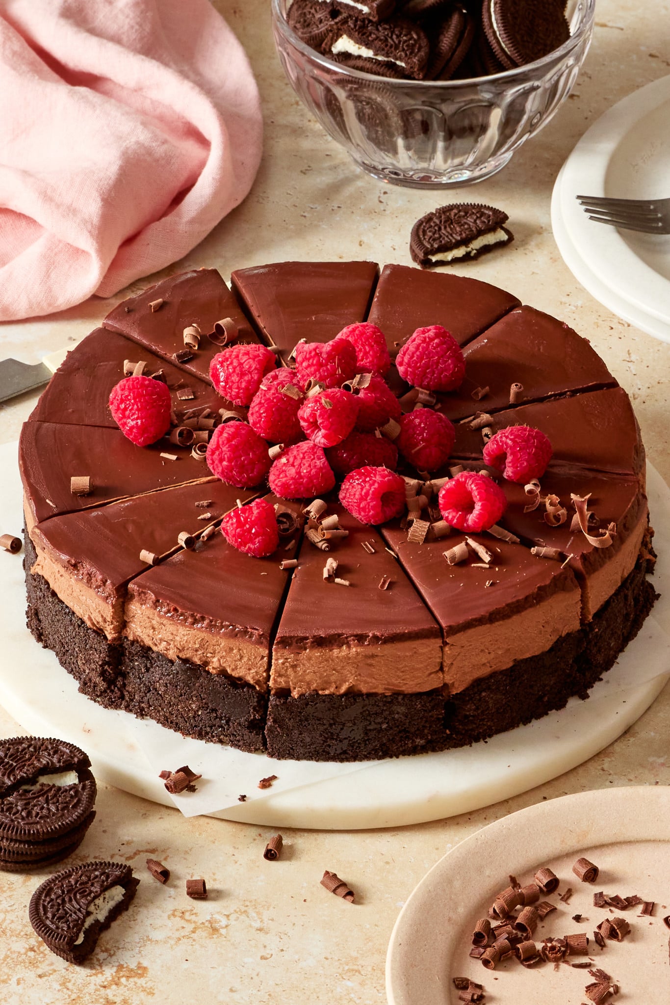 No-bake chocolate cheesecake sliced and topped with fresh raspberries and chocolate shavings.