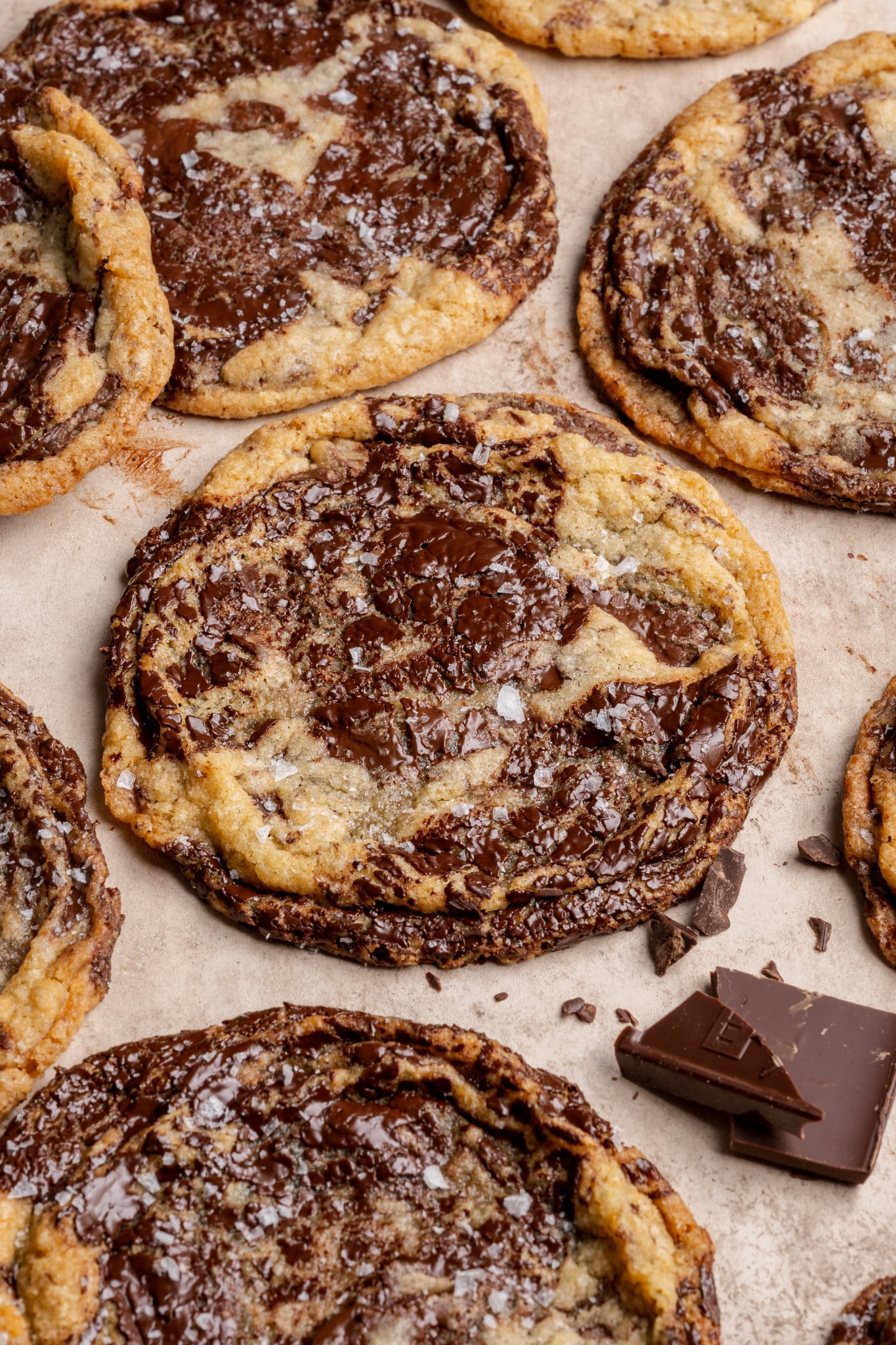 Pan banging chocolate chunk cookies baked and garnished with flaky sea salt.