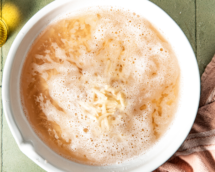 Soaking the shredded potatoes in cold water.