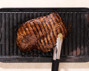 Cooking carne asada on grill pan.