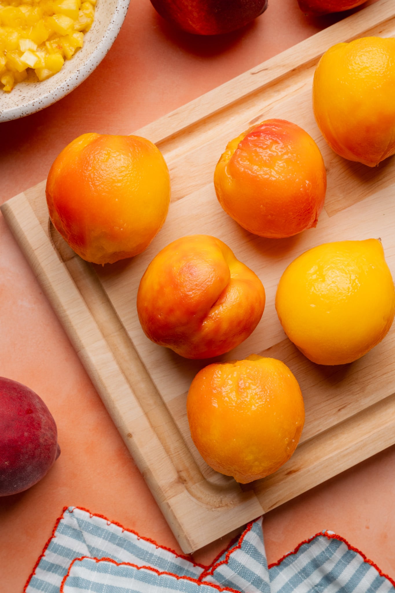 Peeled peaches on cutting board.