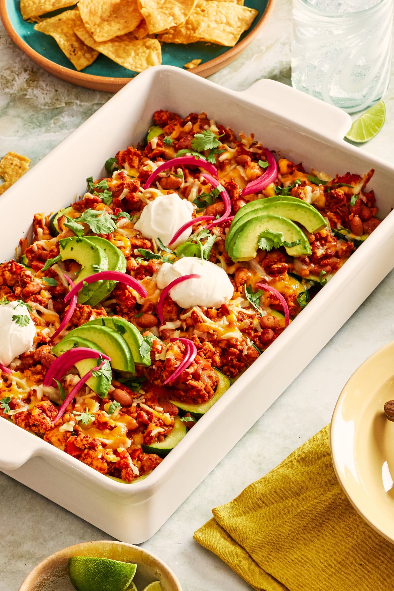 Ground turkey taco zucchini boats topped with sour cream, avocado and pickled red onions.
