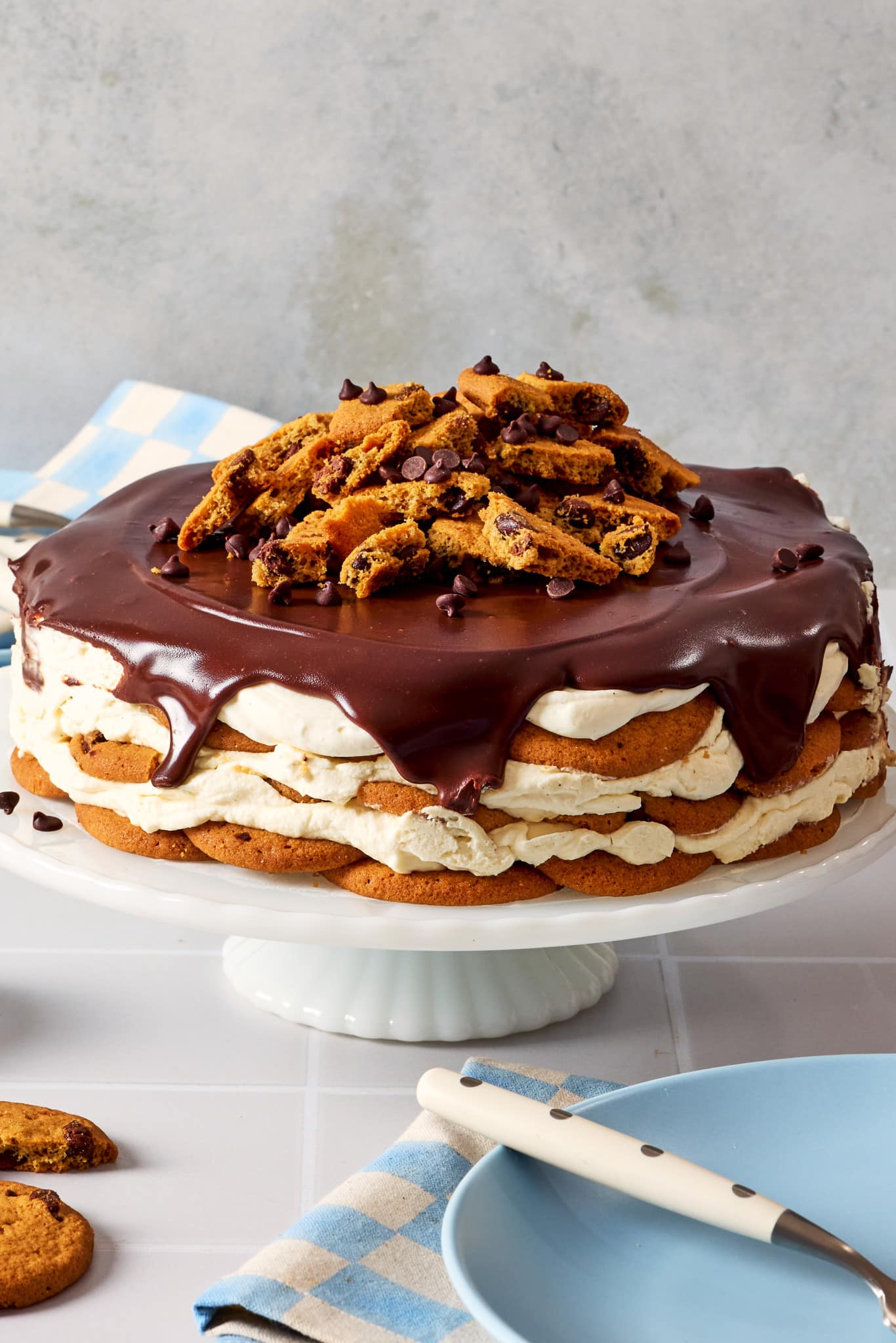 Chocolate chip cookie icebox cake served on cake and topped with extra chocolate chips and cookie pieces.
