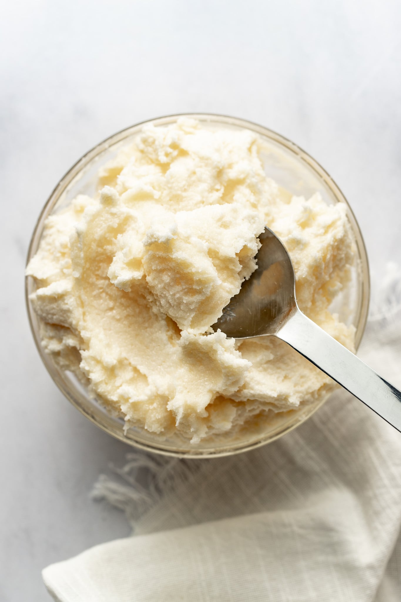 Spoon picking up creamed butter and sugar out of bowl.