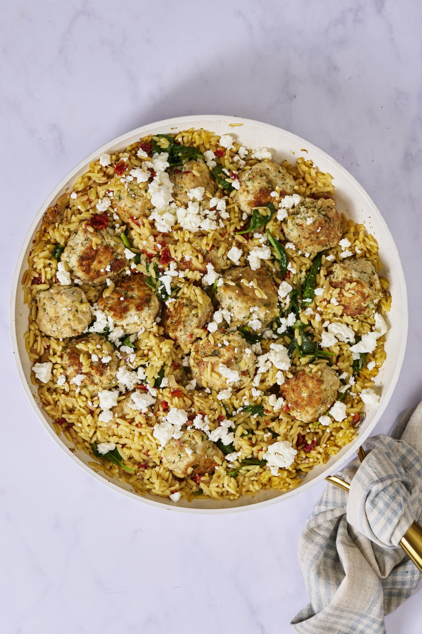 Mediterranean meatball and orzo cooked in a large skillet.