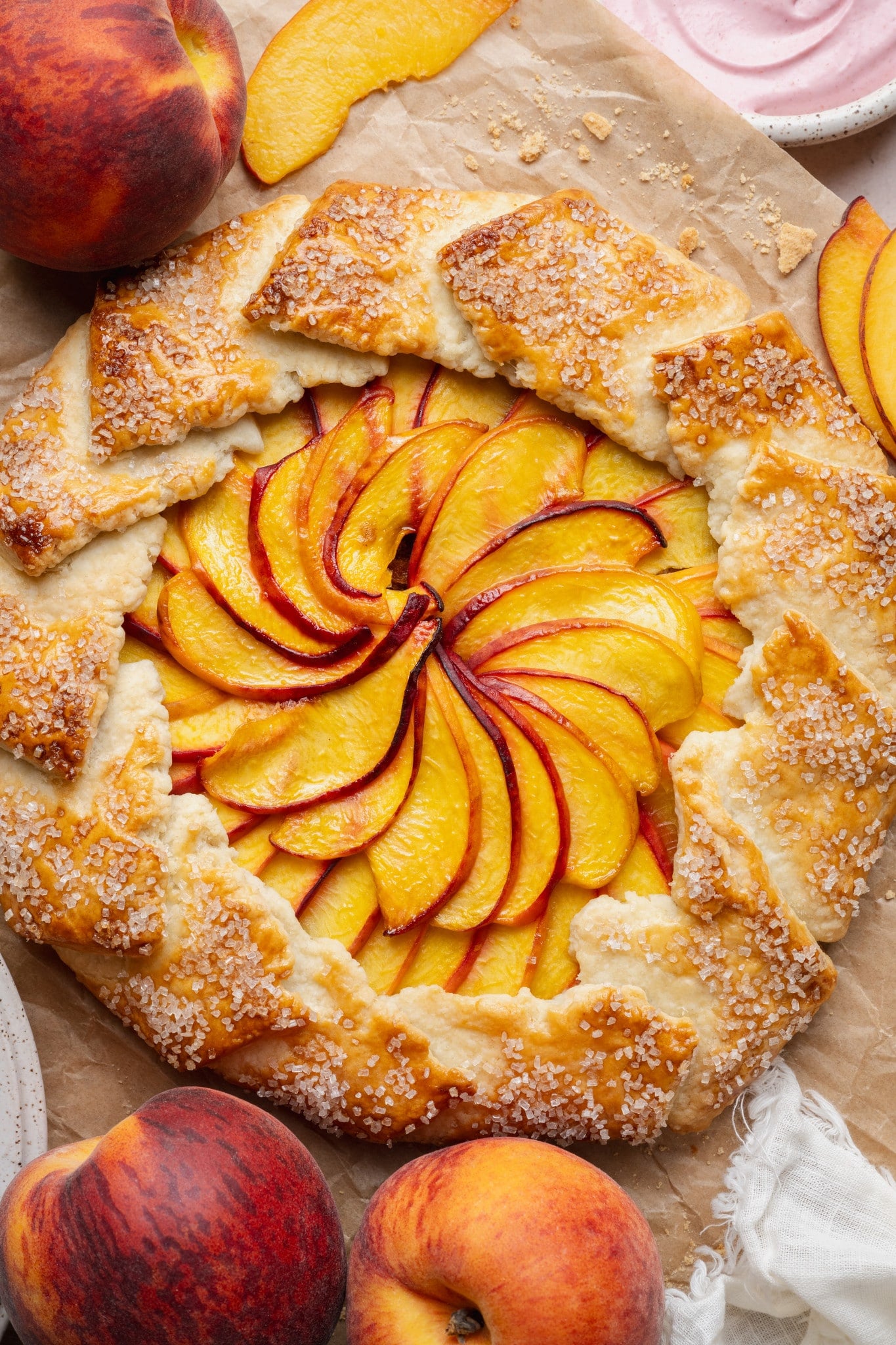 Peach galette baked on parchment paper.