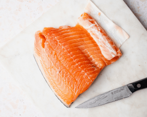 Filet of salmon with knife beside it.
